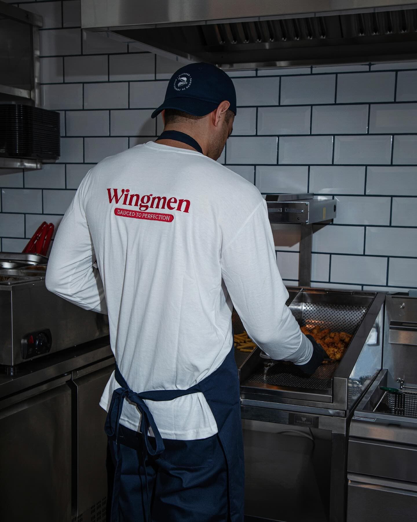 Wingmen cook preparing wings behind the pass